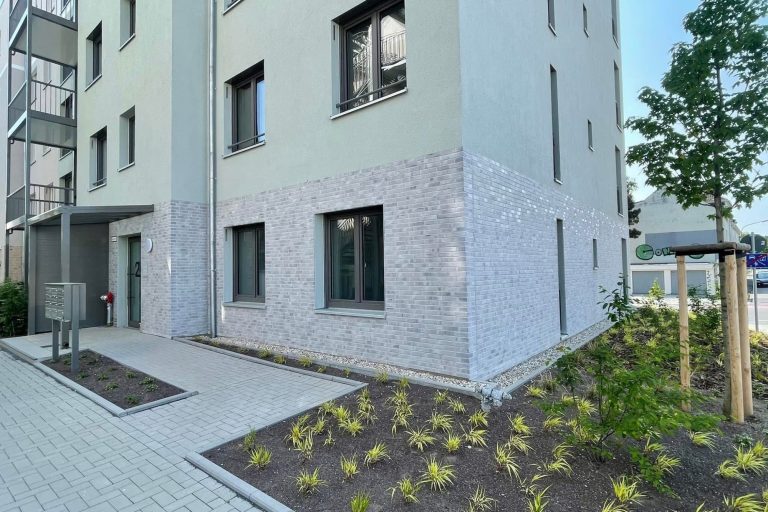 Klinkerriemchen auf Modernem Wohngebäude mit hellem Putz und begrünter Umgebung 