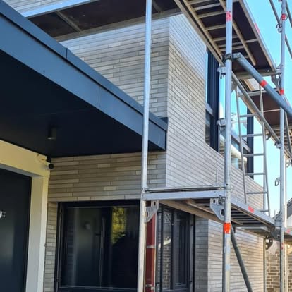 Fassade eines Gebäudes mit Gerüst und neuer Verkleidung.